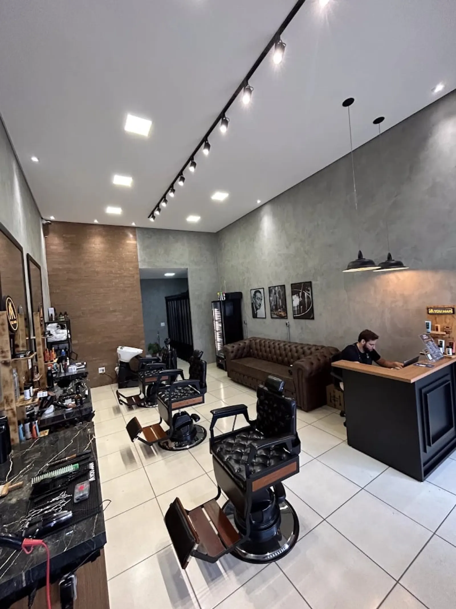 Interior da Tresor Barbearia, ambiente sofisticado com poltronas e iluminação calorosa